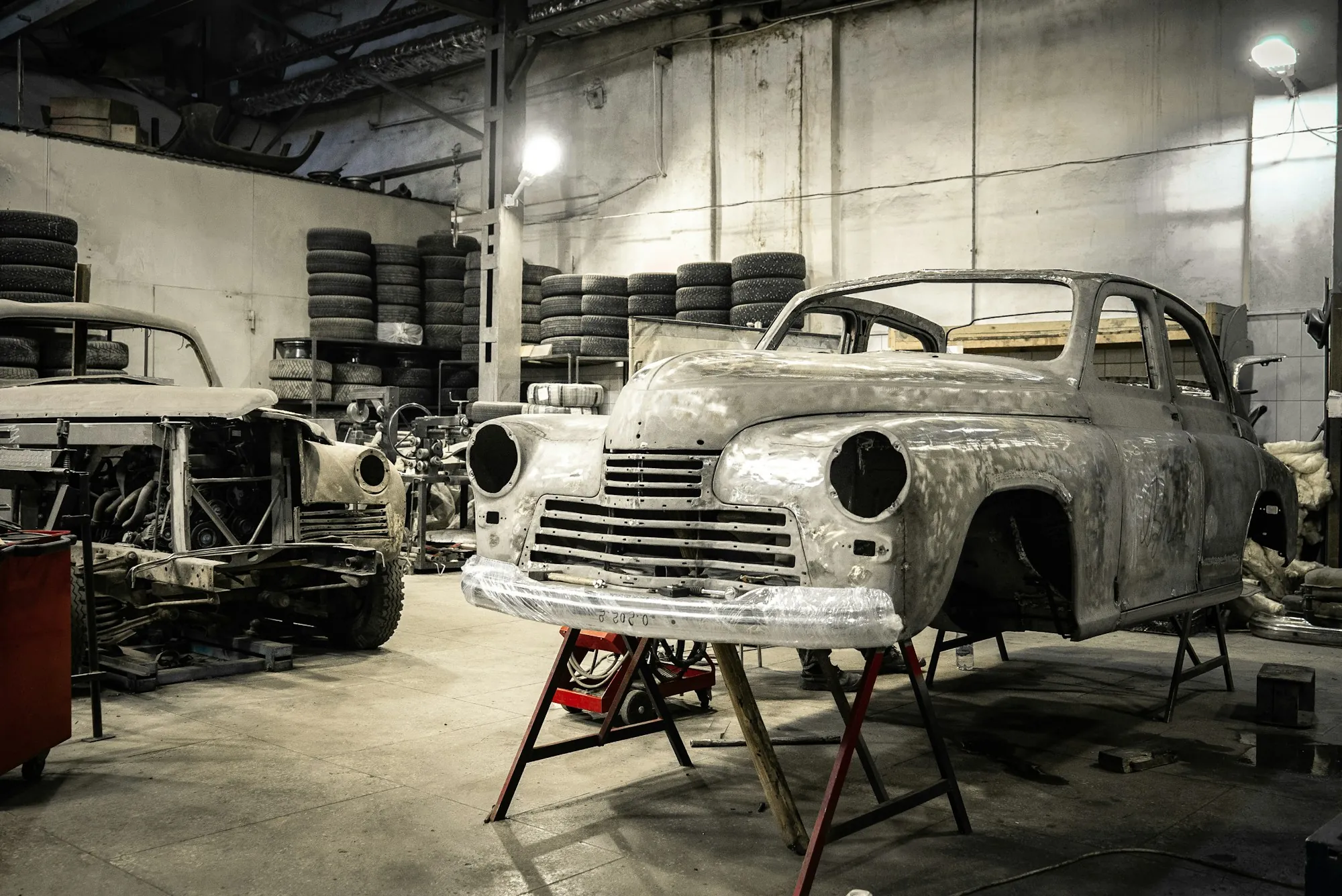 Bare-metal classic car body being restored in a shop