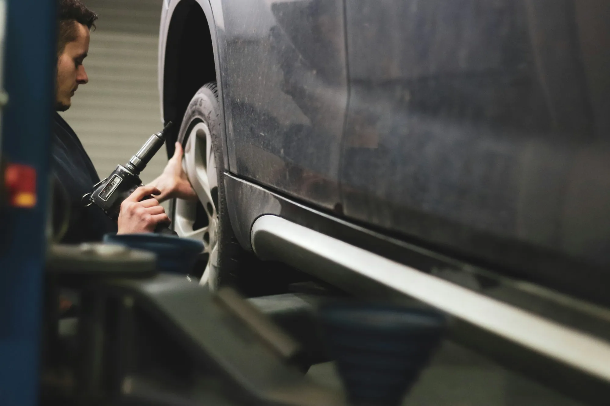 Technician inspecting the side panel of a dark car