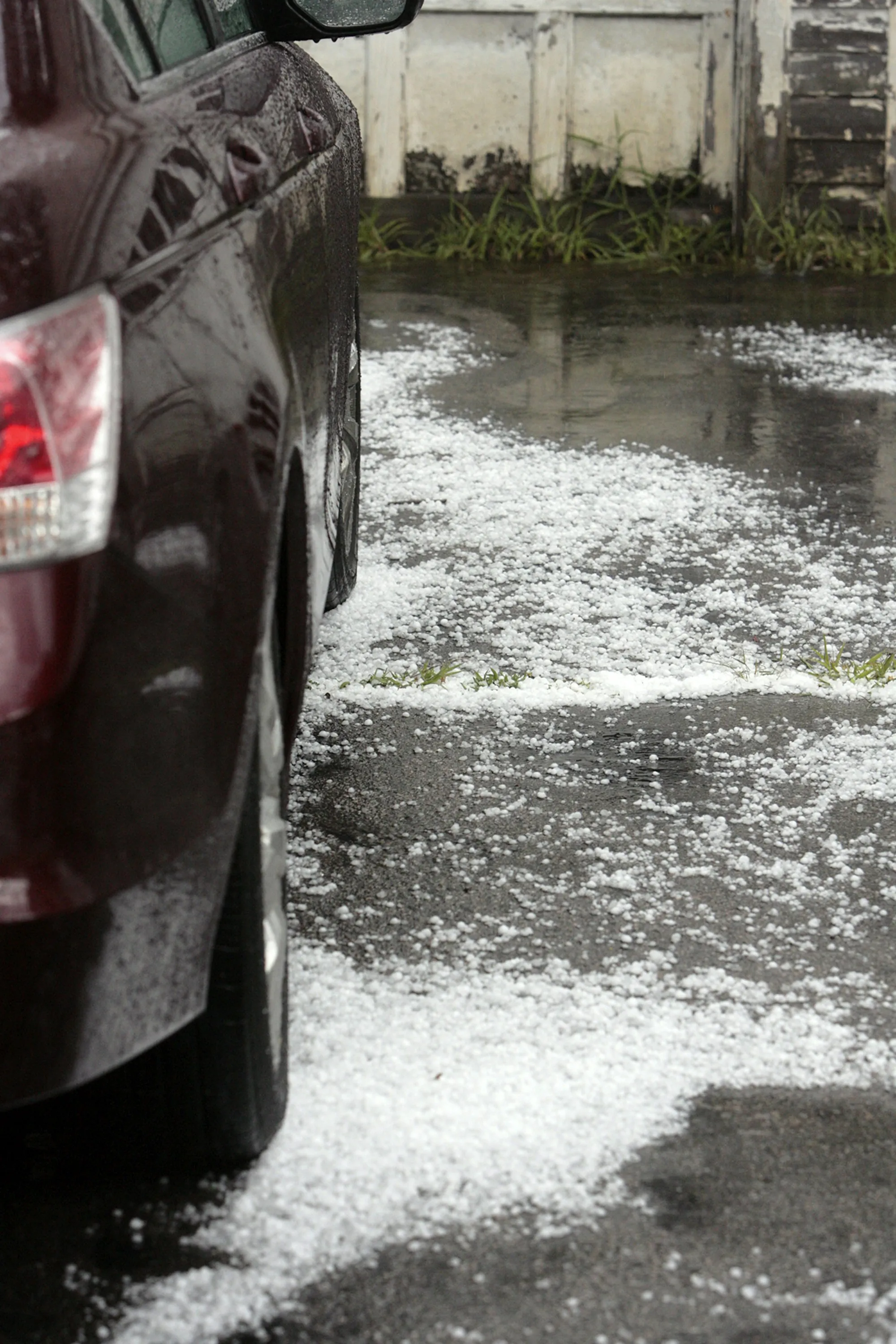 Car on a wet road covered in hailstones after a storm
