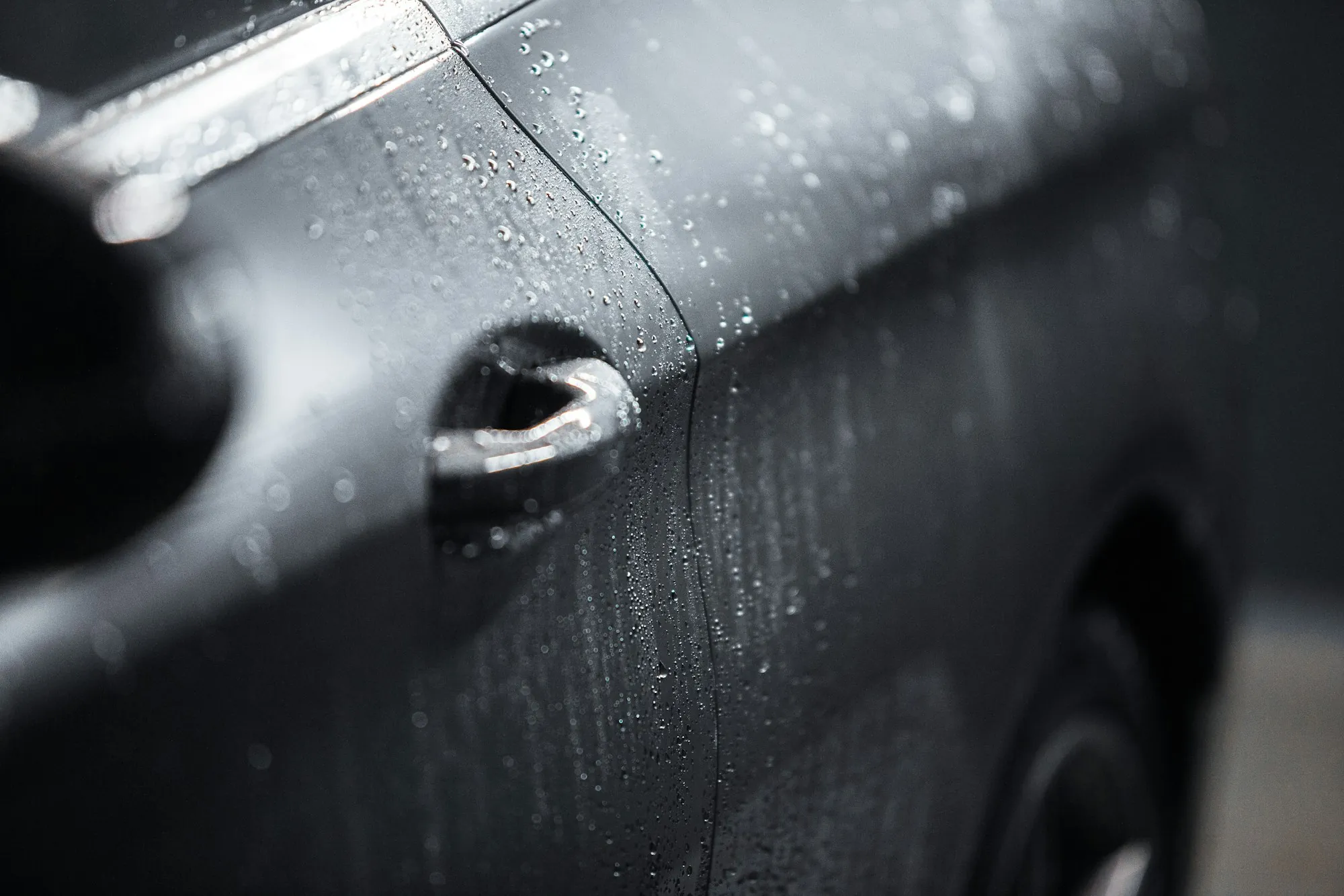 Close-up of a scratched panel on a dark car