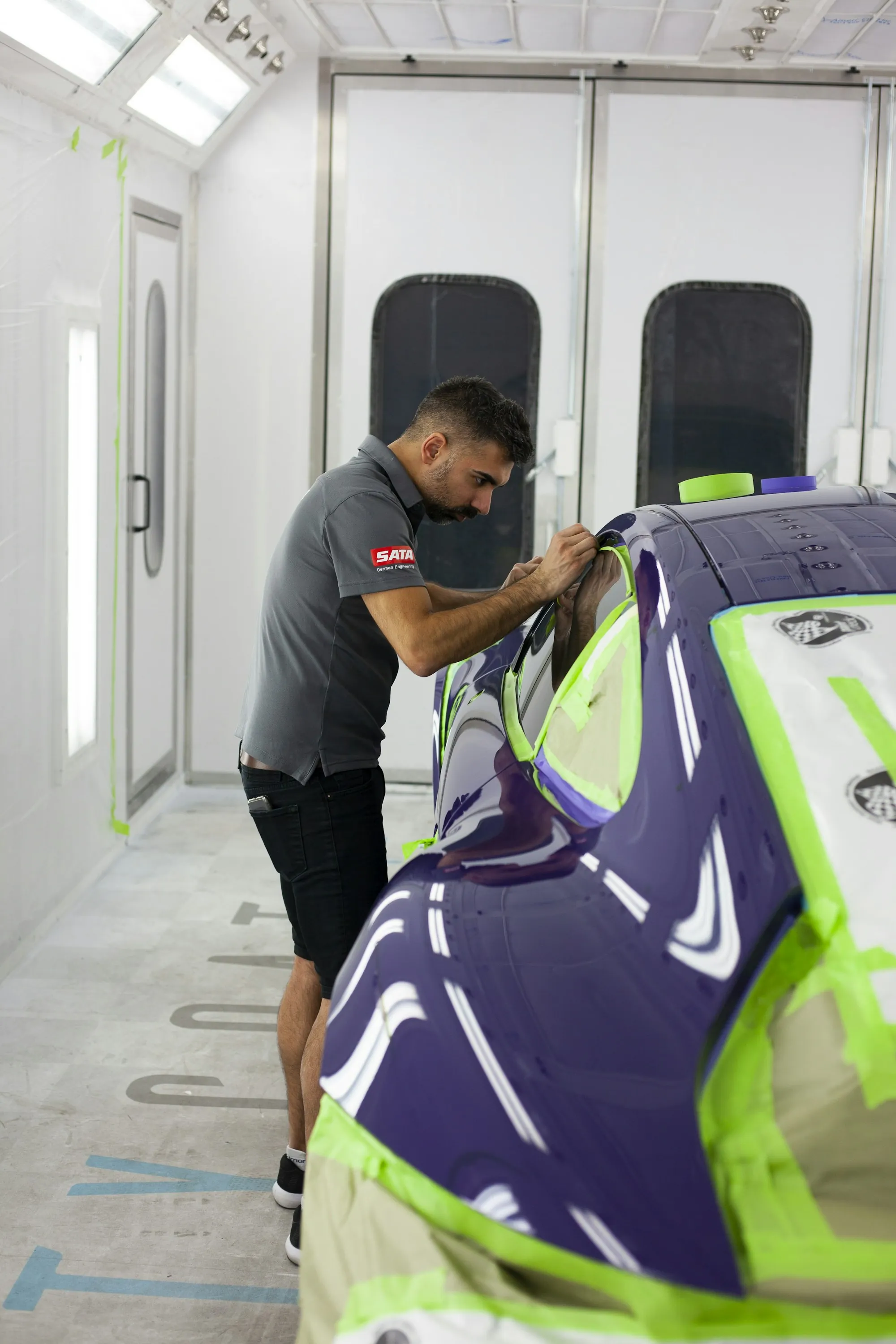 Technician working on a car's bodywork in a garage